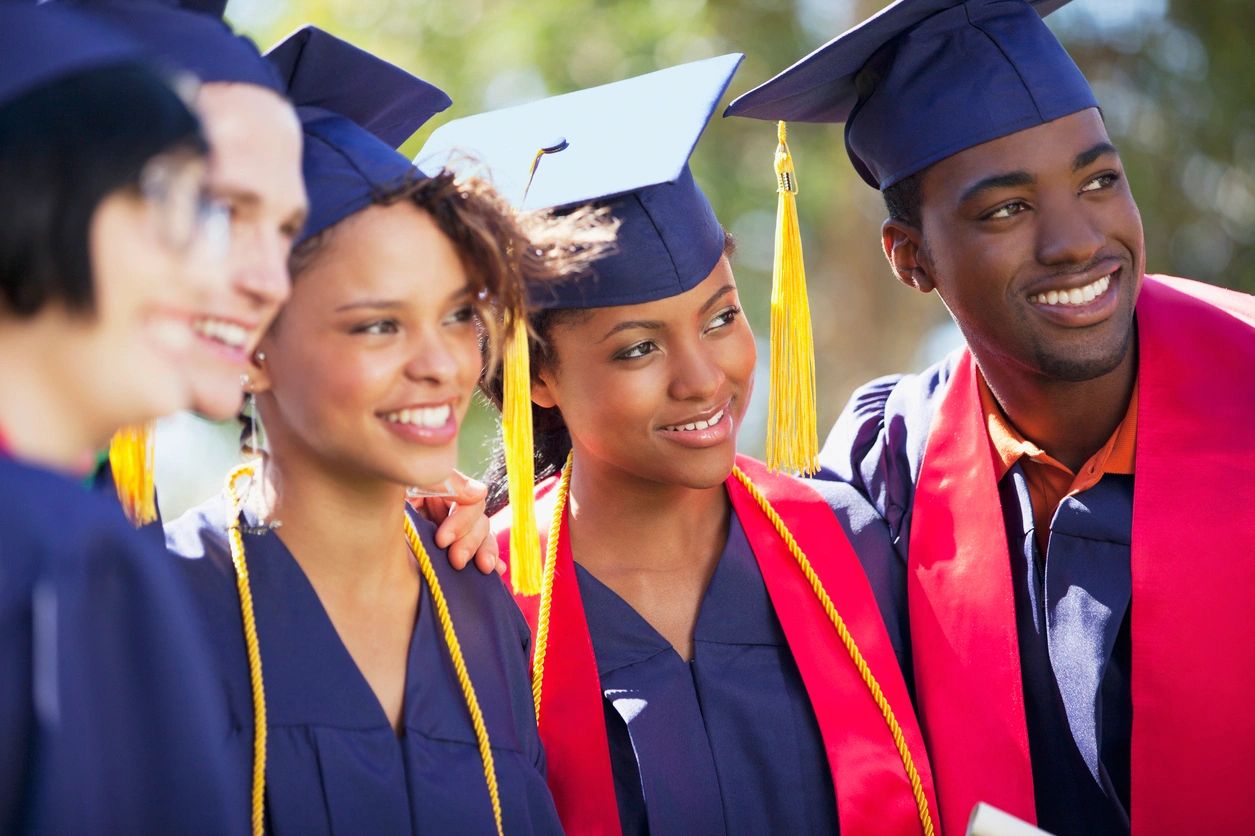 Happy graduates in caps and gowns celebrating their achievement.